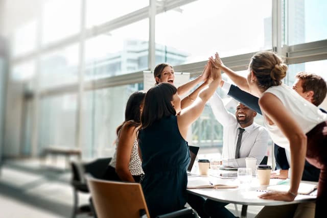 Employees standing and giving a group high five