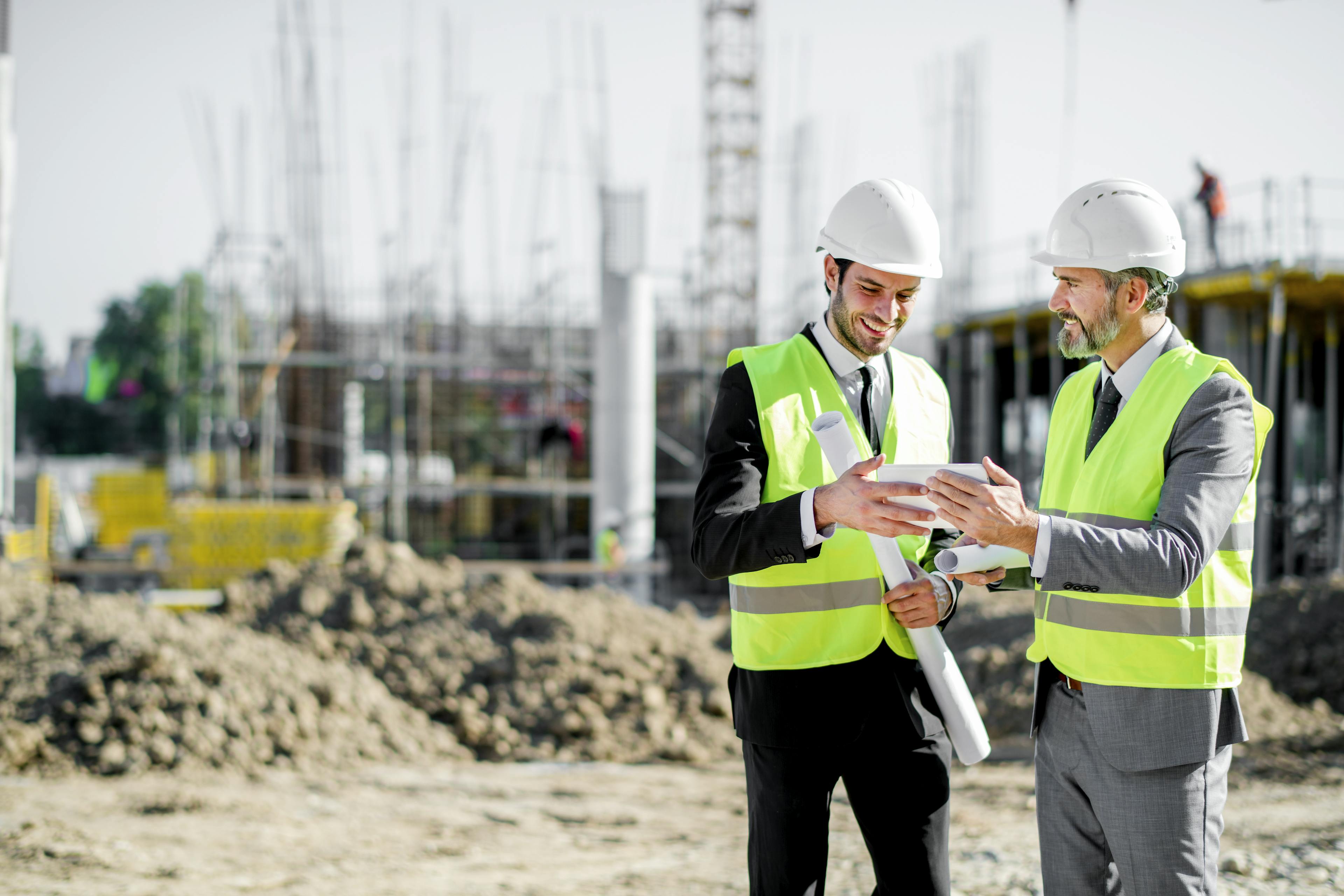 Two construction executives looking at an iPad on a site