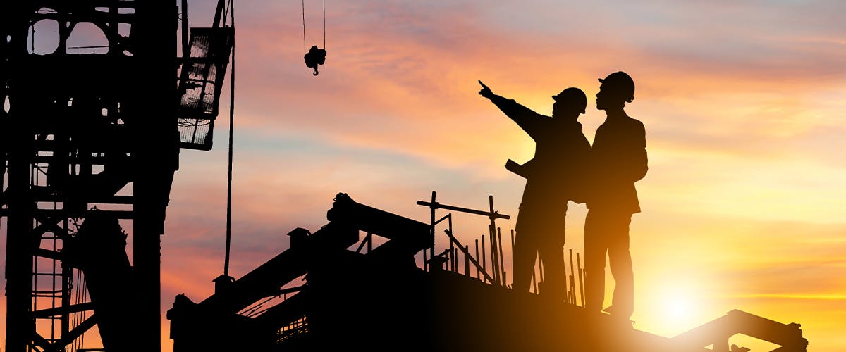 Two construction workers at sunset