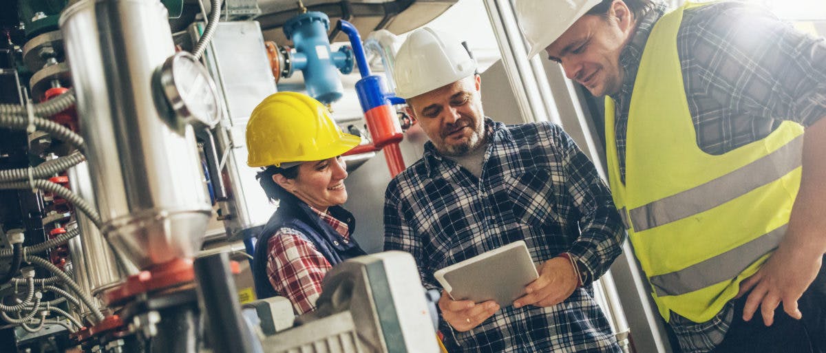 Three construction workers looking at an iPad 1200x513