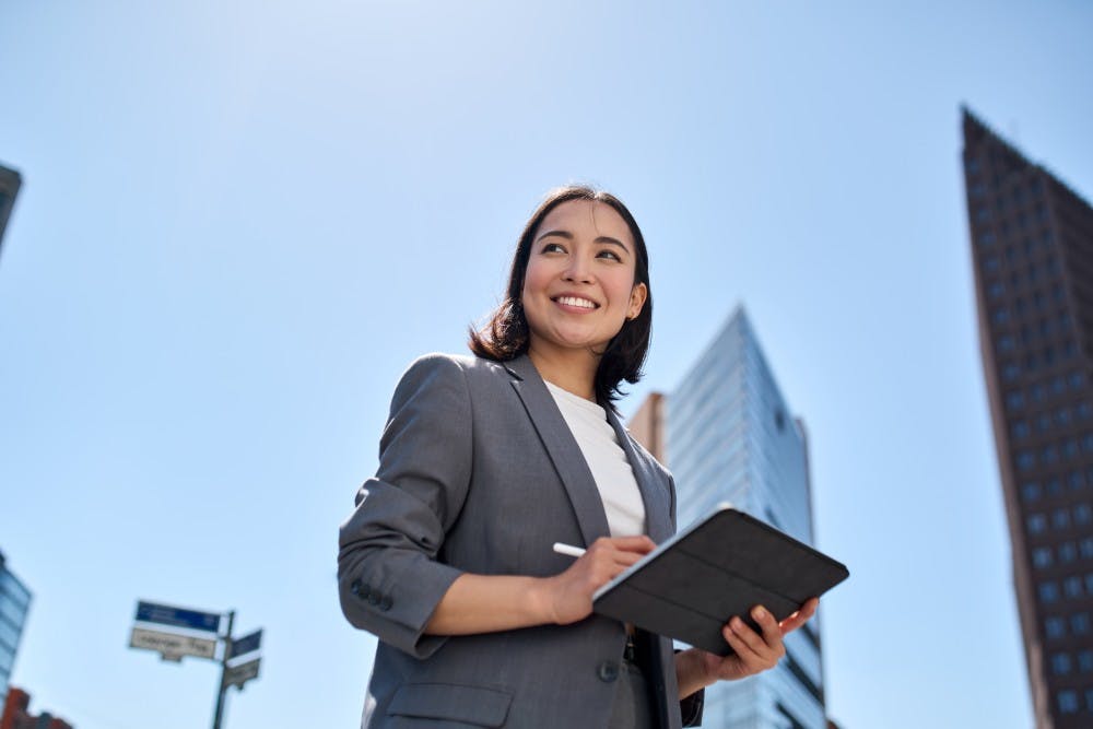 Female executive standing holding a laptop