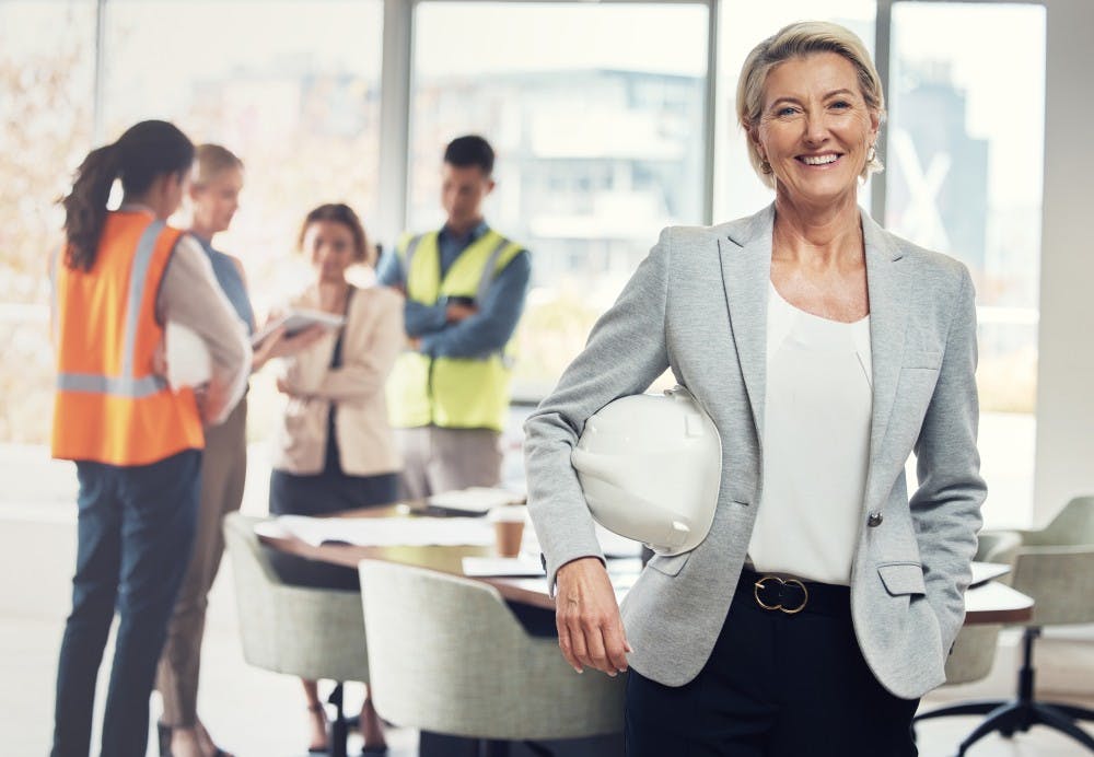 Female executive with hard hat in office