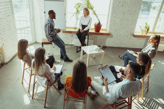 Group of employees listening to two people talk