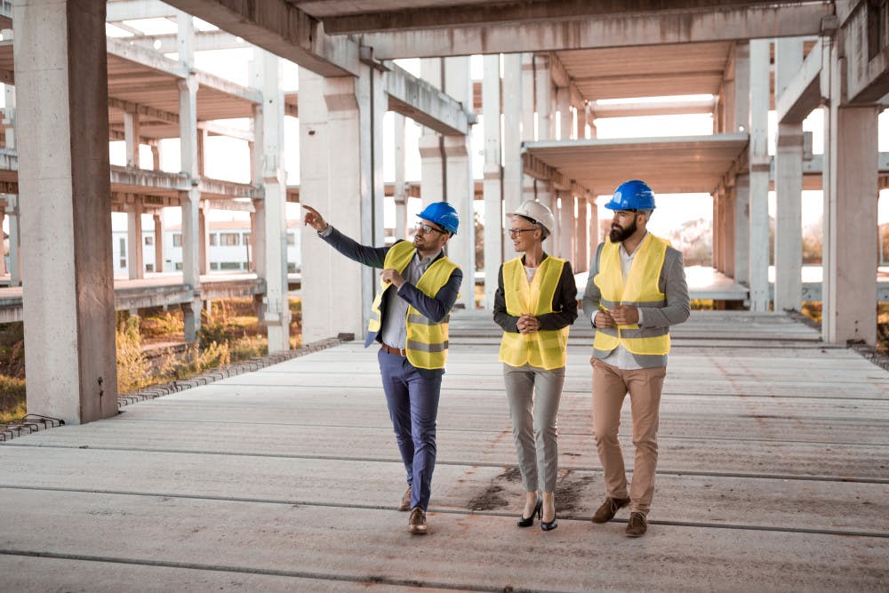 Three construction workers walking in a job site