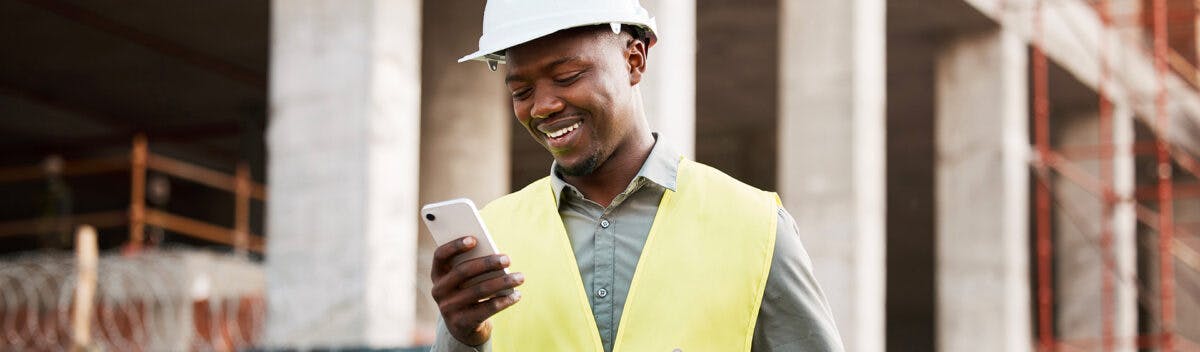 Construction worker looking at his iPhone - Construct CT Webinar Landing Page Image Cropped 1200x352
