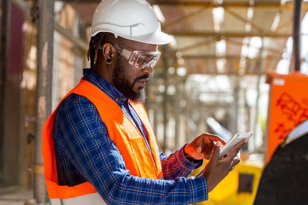 Construction worker looking at iPad at a construction site