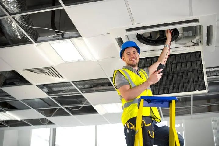 Male construction worker installing HVAC