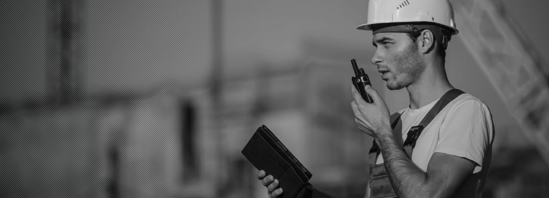 Male construction worker on walkie talkie black and white